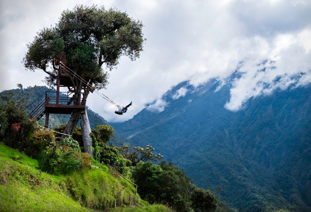 Tourist swinging on the swing of the end of the world (Columpio del fin del mundo) in Baños, Ambato province, Ecuador. The tree house, Latin America