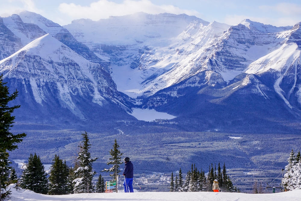 Skiing at Lake Louise in the Canadian Rockies, mountains and frozen Lake Louise in the distance