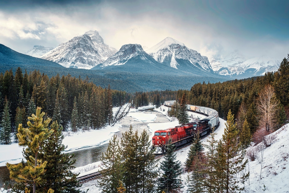 red freight train coming around Morant's Curve in Banff National Park in Canada in winter