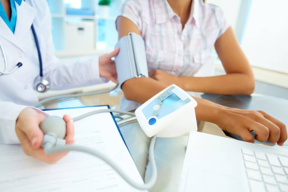 Close-up of tonometer by patients arm during blood pressure measuring at medical consultation