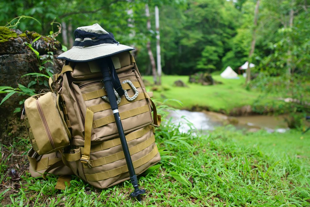 Road Trip Packing List Essentials Backpack with hat and hiking poles