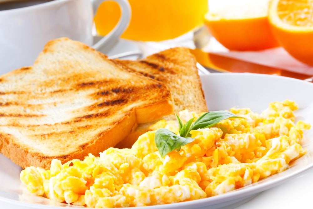 Road Trip mistake no breakfast plate with scrambled eggs, toasts, juice and coffee