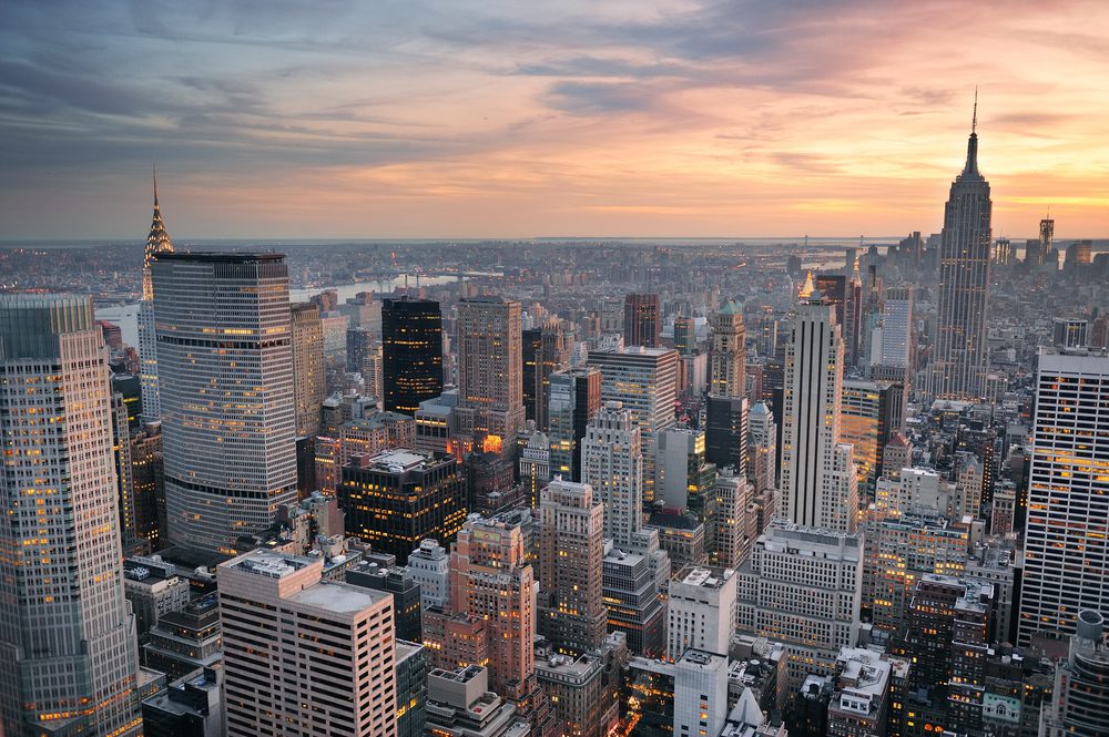 New York City skyline aerial view at sunset with colorful cloud and skyscrapers of midtown Manhattan.