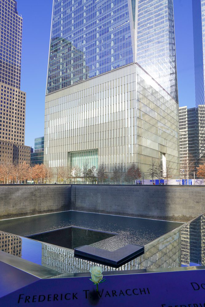 Reflecting pool at the 9/11 Memorial and Museum with One World Observatory in the background.