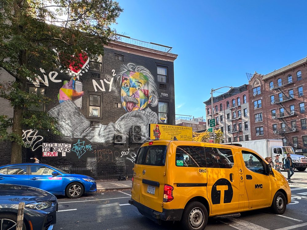 Einstein Street art with a taxi passing by Chelsea NYC