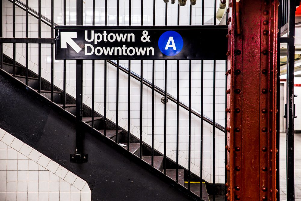 NYC Subway A Train sign with a staircase in the background