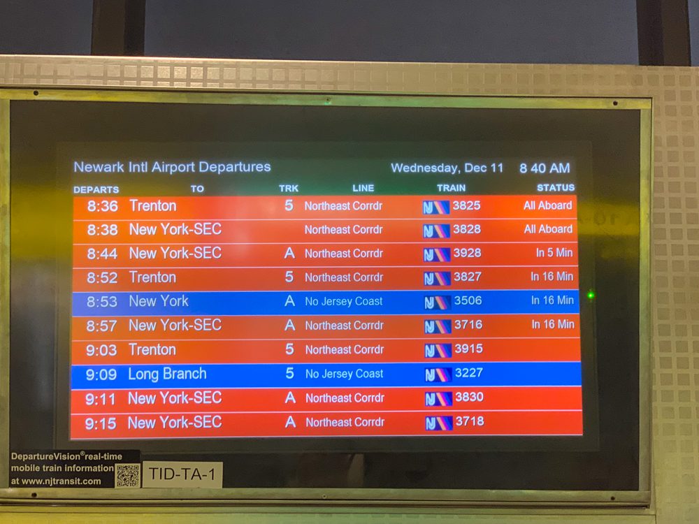 Screen showing trains heading to New York City from Newark Airport