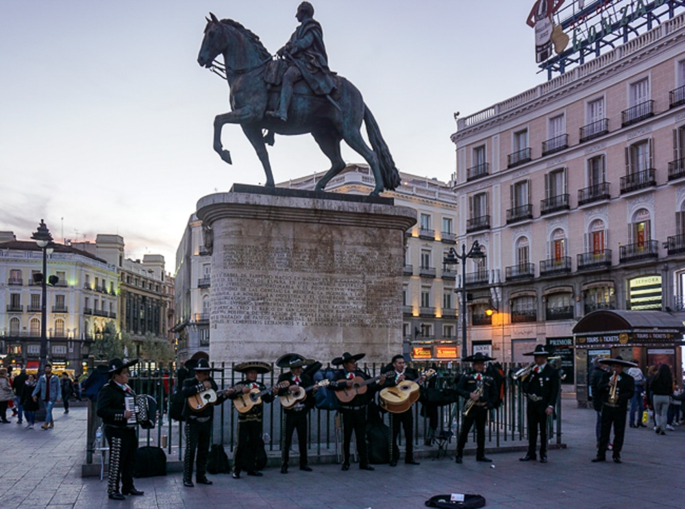 Puerta del Sol in Madrid Spain with a mariachi band playing in front of a statue of a horse with a rider