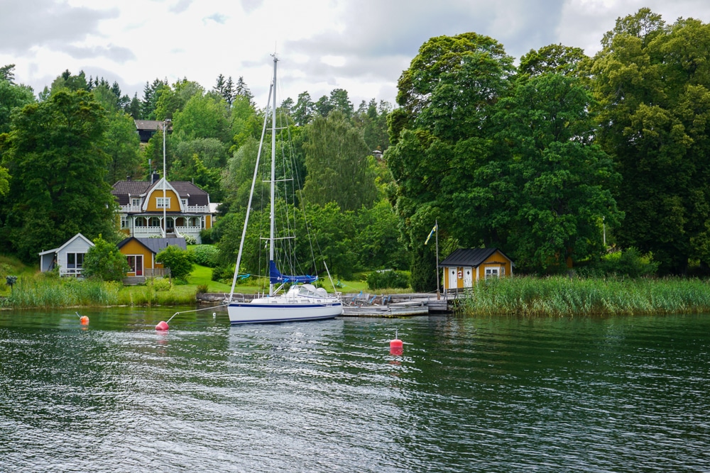 house on the water with a sailboat parked out front Stockholm Sweden Archipelago