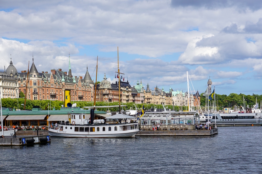 View of a Stockholm neighbood from the water with boats in the foreground and buildings in the background