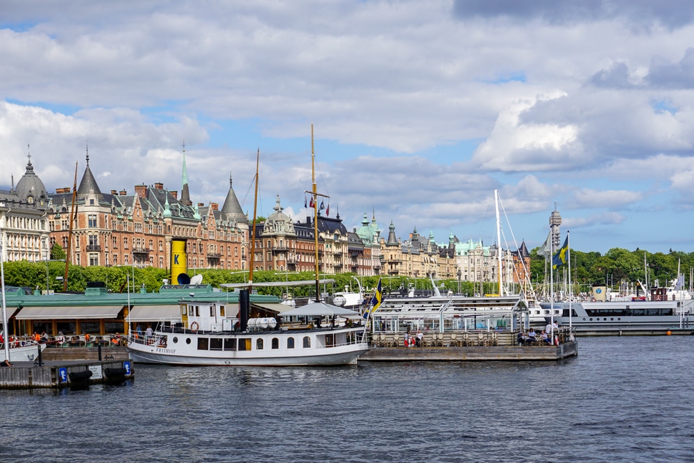 View of a Stockholm neighbood from the water with boats in the foreground and buildings in the background
