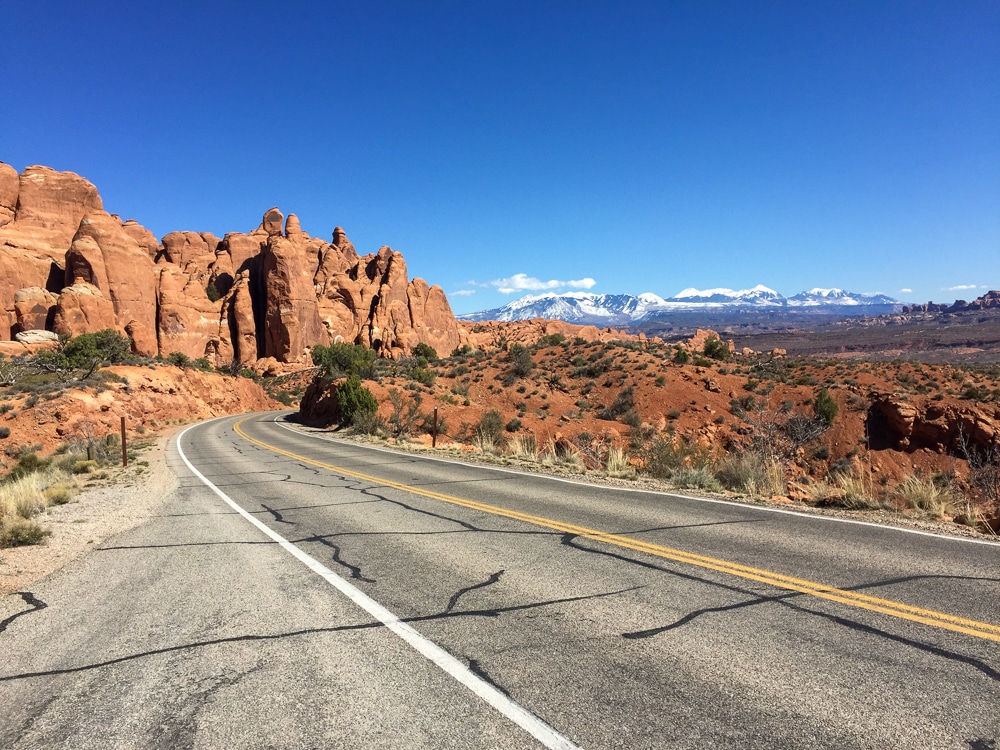 road with red mountains in the distance in Utah