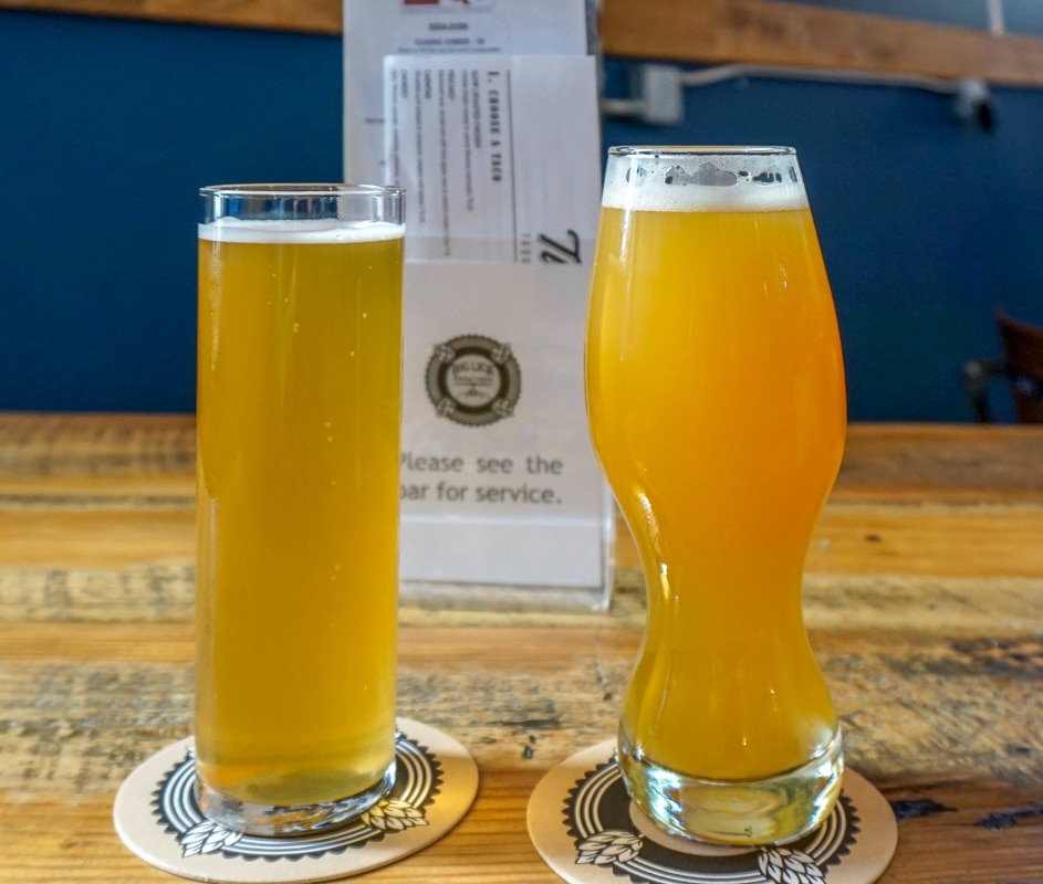 2 tall glasses of beer on a table