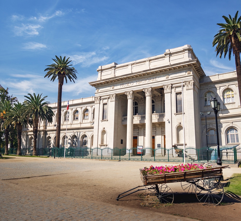 history museum in santiago chile, columned building of white stone with palm trees on either side.