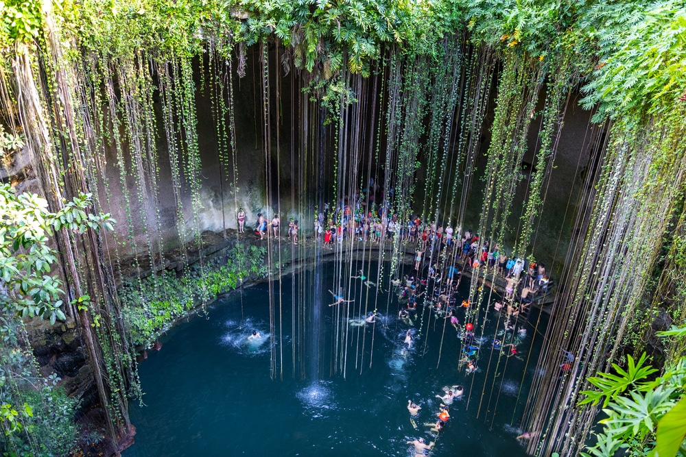 Swimming at Cenote Ik Kil in Yucatan, Mexico, a natural pit, or sinkhole near Chichen Itza. Ik Kil was sacred to the Mayans who used this cenote for both relaxation and ritual services centuries ago.