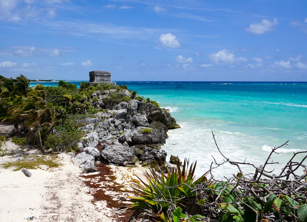 Tulum Mayan ruins sitting on a cliff overlooking turquoise sea